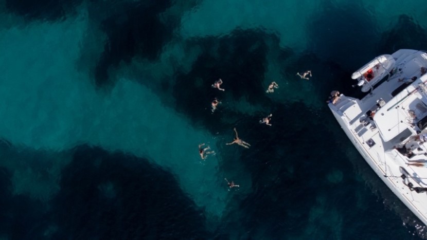 Drohnenaufnahme vom Katamaran-Erlebnis mit mehreren im Wasser schwimmenden Personen